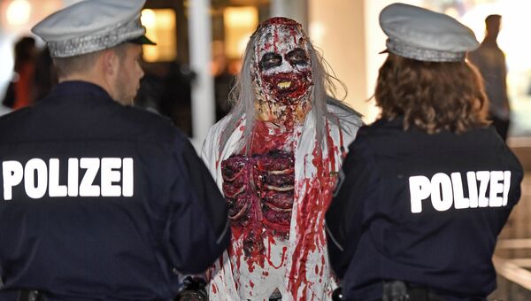Участник парада на Хэллоуин в немецком городе Эссен общается с полицией