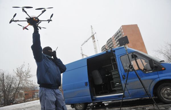 Сотрудник правоохранительных органов демонстрирует новый беспилотный летательный аппарат Шестикоптер