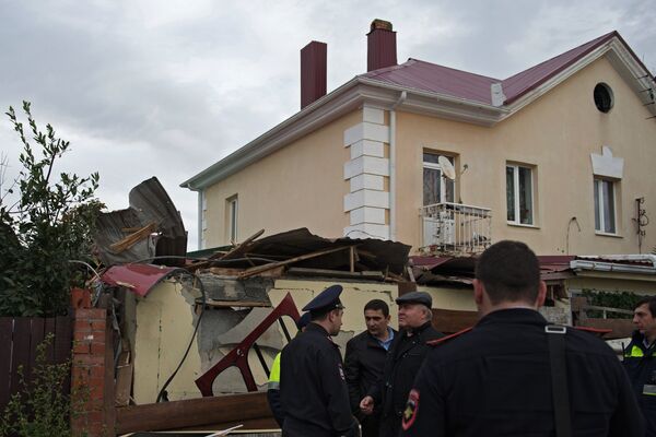 Сотрудники правоохранительных органов у места падения вертолета на крышу частного жилого дома в Адлерском районе Сочи