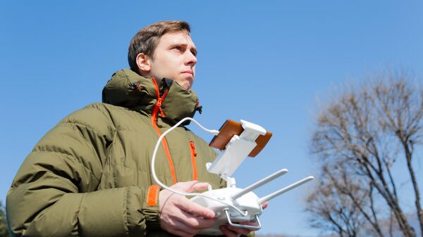 Мужчина управляет беспилотным летательным аппаратом. Архивное фото
