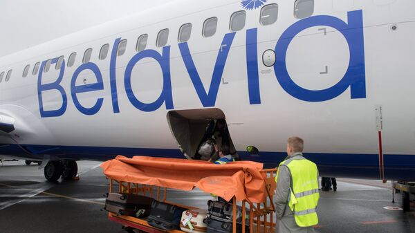 Сотрудники Международного аэропорта Жуковский загружают чемоданы пассажиров в багажный отсек самолета белорусской авиакомпании Белавиа