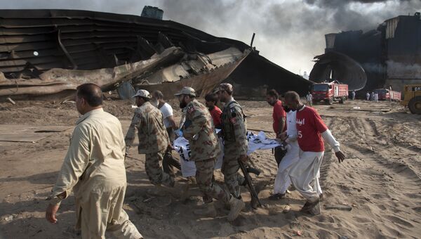 Сотрудники спецслужб Пакистана на месте взрыва при утилизации судна в городе Гадани. 1 ноября 2016