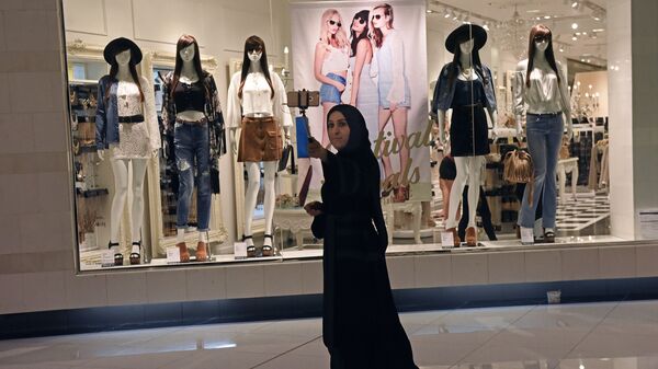 Посетительница фотографируется в дубайском торгово-развлекательном центре The Dubai Mall