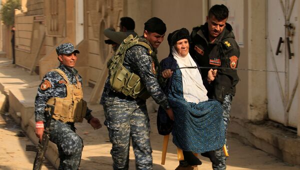 Иракские военные помогают женщине в городе Хаммам эль-Алиль во время операции по освобождению Мосула от ИГ. 6 ноября 2016