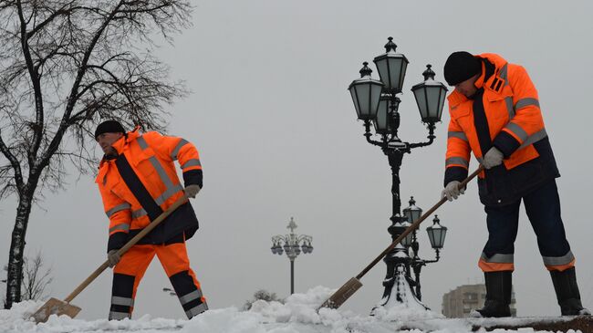 Работники коммунальных служб убирают снег на улицах Москвы