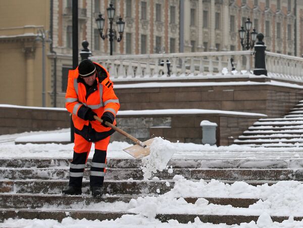 Сотрудник коммунальных служб убирает снег на улицах Москвы
