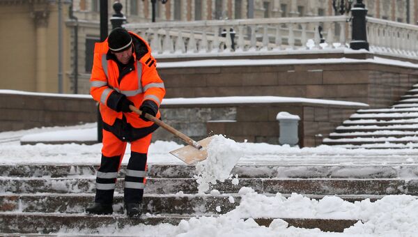 Сотрудник коммунальных служб убирает снег на улицах Москвы. Архивное фото