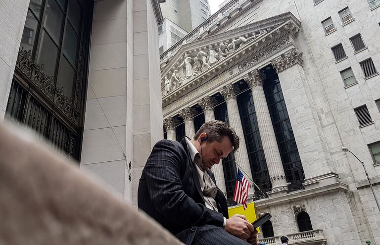 Мужчина неподалеку от здания Нью-Йоркской фондовой биржи Мужчина неподалеку от здания Нью-Йоркской фондовой биржи