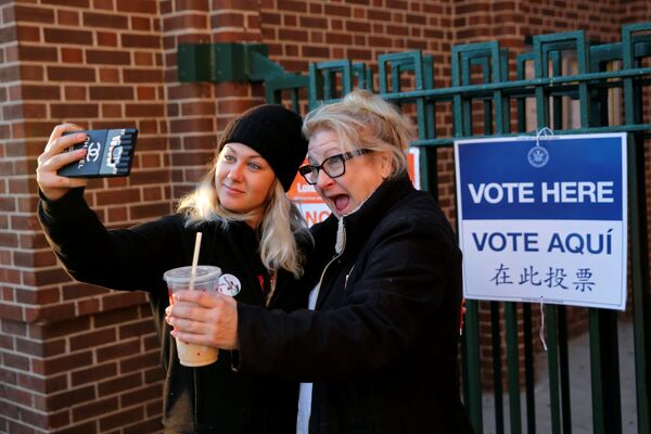 Впервые проголосовавшая девушка делает сэлфи с мамой возле избирательного участка в Нью-Йорке