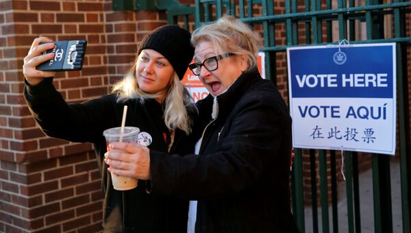Впервые проголосовавшая девушка делает сэлфи с мамой возле избирательного участка в Нью-Йорке