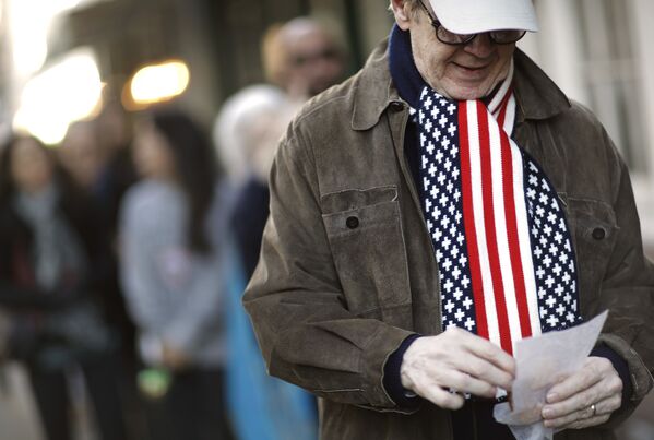 Мужчина в шарфе под цвет флага США на избирательном участке в Нью-Йорке