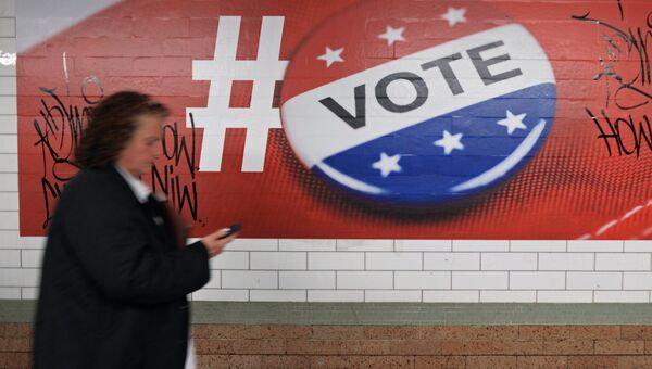 Прохожая у плаката, посвященного голосованию на выборах президента США, в Нью-Йорке. Архивное фото