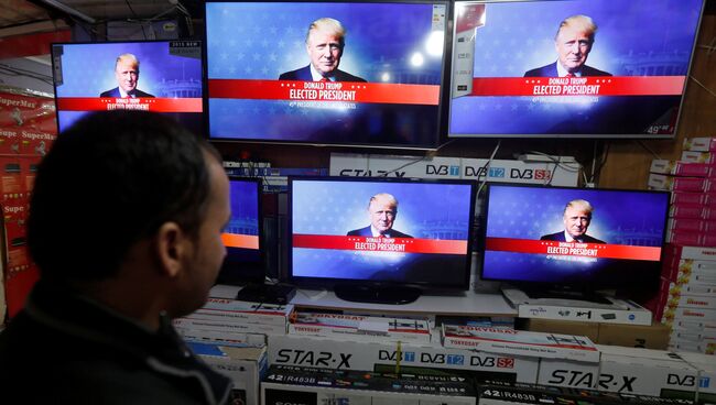 Мужчина смотрит трансляцию объявления результатов голосования на выборах президента США в Кабуле
