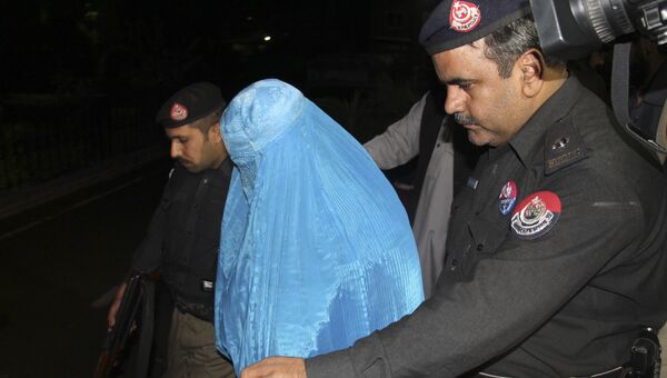 Пакистанские полицейские сопровождают афганку Шарбат Гулу перед ее депортацией в Афганистан. 9 ноября 2016