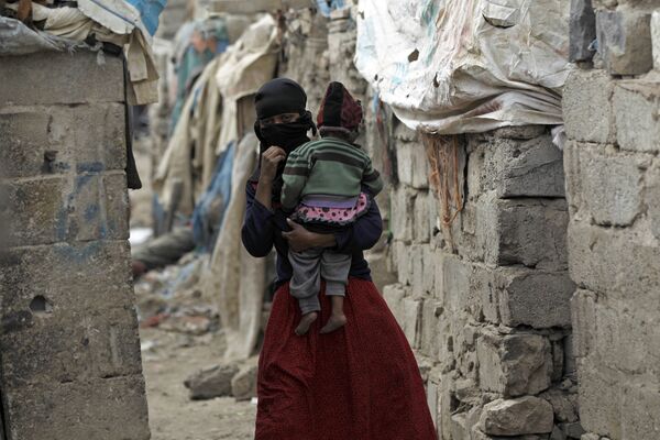 Женщина из сообщества Ахдам с ребенком в городе Сана, Йемен