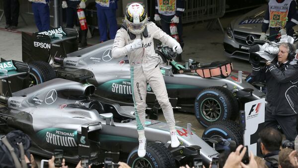 Пилот Мерседеса британец Льюис Хэмилтон празднует победу на 20-м этапе чемпионата Формулы-1 Гран-при Бразилии. 13 ноября 2016