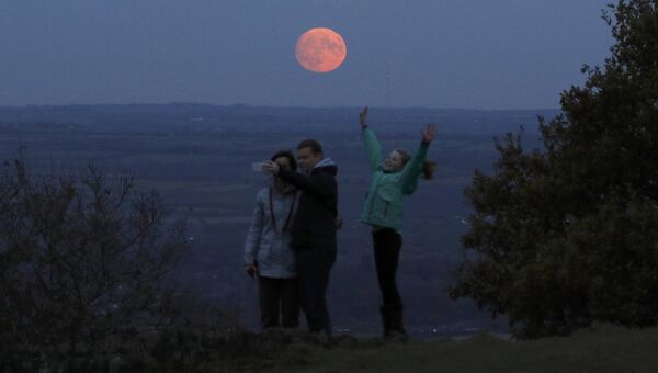 Семья фотографируется на фоне луны, Лафборо, Великобритания. 13 ноября 2016