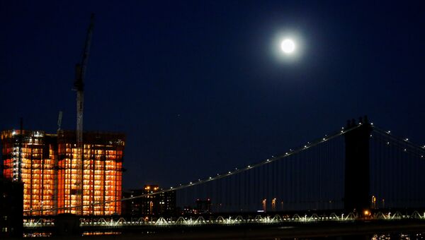 Луна над Манхэттенским мостом накануне суперлуния в Нью-Йорке, США. 13 ноября 2016