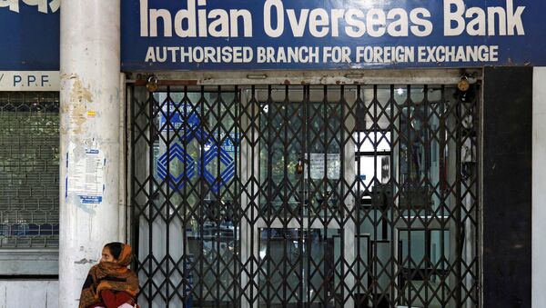 Женщина у закрытых дверей банка в Индии