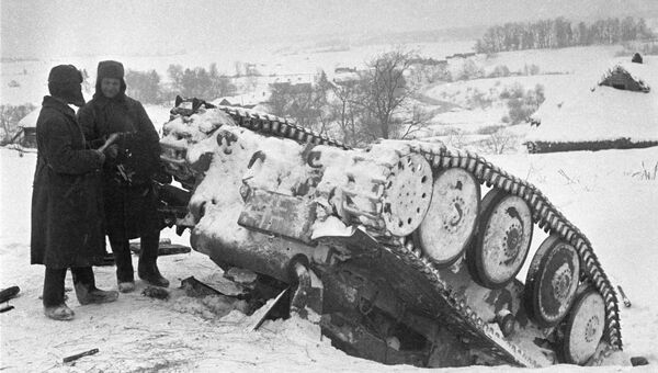 Разгром немецких танковых дивизий под Москвой. Красноармейцы стоят рядом с подбитым немецким танком