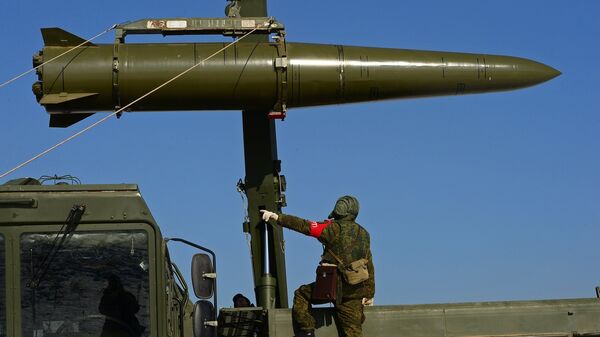 Военнослужащий вооруженных сил РФ контролирует загрузку ракеты транспортно-заряжающий машиной на самоходную пусковую установку оперативно-тактического ракетного комплекса Искандер-М. Архивное фото