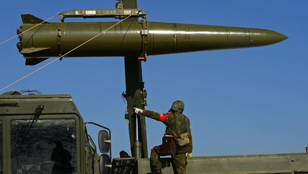 Военнослужащий вооруженных сил РФ контролирует загрузку ракеты транспортно-заряжающий машиной на самоходную пусковую установку оперативно-тактического ракетного комплекса Искандер-М. Архивное фото