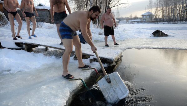 Любители зимнего плавания из клуба моржей Белый Медведь у проруби перед купанием на пруду в Екатеринбурге