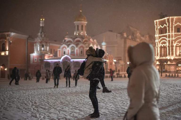 Прохожие на Красной площади в Москве во время снегопада Прохожие на Красной площади в Москве во время снегопада
