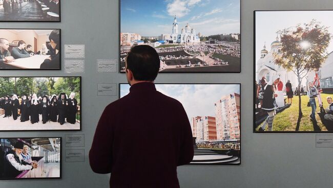 Посетитель на фотовыставке Сын Церкви в храме Христа Спасителя в Москве, посвященной 70-летию патриарха Кирилла