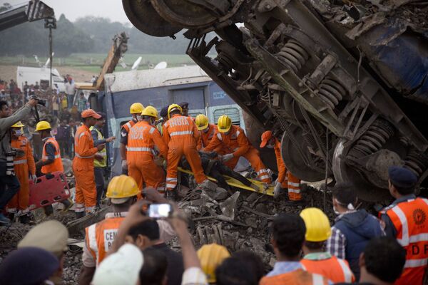Спасатели на месте крушения поезда в штате Уттар-Прадеш, Индия.