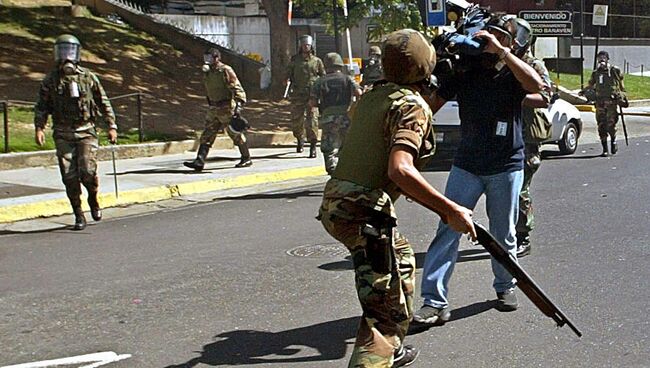 Телеоператор снимает разгон демонстрантов в Каракасе, Венесуэла. Архивное фото