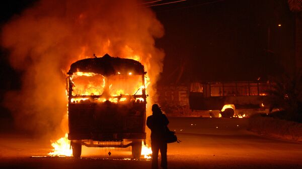Оператор снимает горящий автомобиль в Карачи, Пакистан