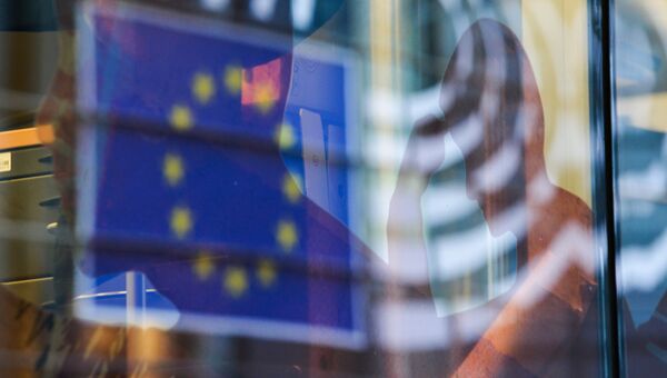 Отражение флага Евросоюза в окне одного из зданий в Брюсселе