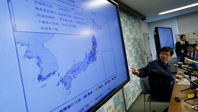 Представитель Японского метеорологического агентства Кодзи Накамура показывает карту землетрясения во время пресс-конференции в Токио, Япония