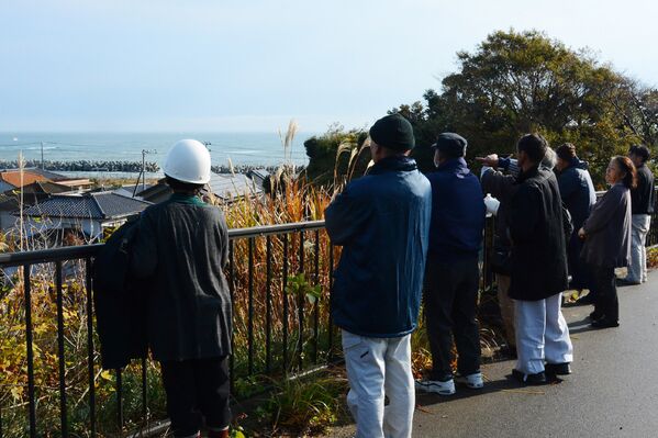 Жители смотрят на море после предупреждения о возможном цунами в Иваки, Япония