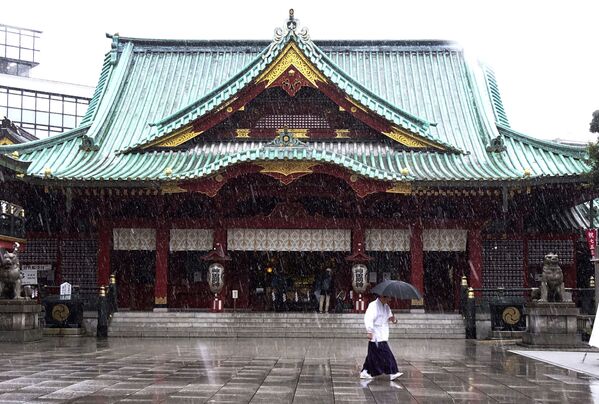 Служитель Храма Канда Мёдзин во время снегопада в Токио, Япония