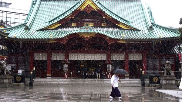 Служитель Храма Канда Мёдзин во время снегопада в Токио, Япония