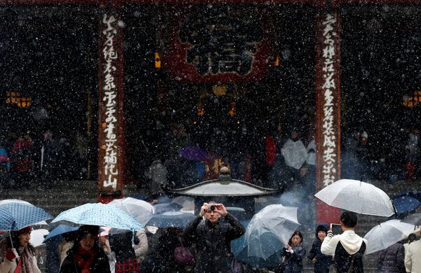 Туристы во время снегопада возле Храма Сэнсо-дзи в Токио, Япония