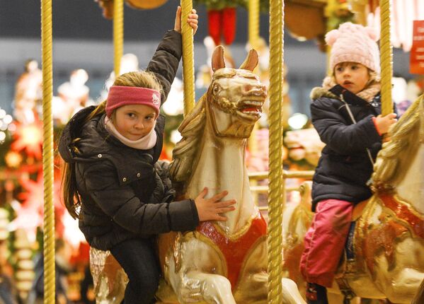 Дети на карусели во время открытия старейшей Рождественской ярмарки Штрицельмаркт в Дрездене