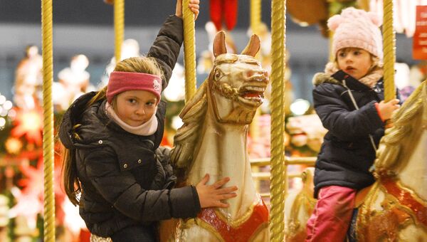 Дети на карусели во время открытия старейшей Рождественской ярмарки Штрицельмаркт в Дрездене