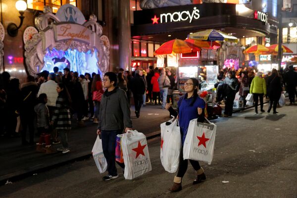 Покупатели выходят из магазина во время распродажи в Черную пятницу в Манхэттене, Нью-Йорк, США
