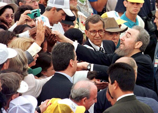 Президент Кубы Фидель Кастро приветствует людей, пришедших на мессу с Папой Иоанном Павлом II на площади Революции в Гаване. 25 января 1998