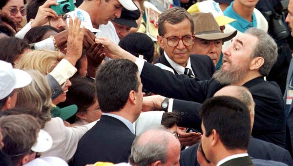 Президент Кубы Фидель Кастро приветствует людей, пришедших на мессу с Папой Иоанном Павлом II на площади Революции в Гаване. 25 января 1998