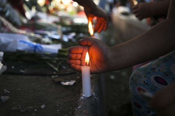 Жители Сантьяго зажигают свечи в память о Фиделе Кастро перед посольством Кубы, Чили