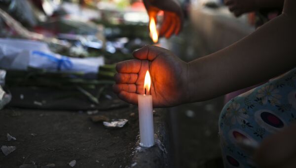 Жители Сантьяго зажигают свечи в память о Фиделе Кастро перед посольством Кубы, Чили