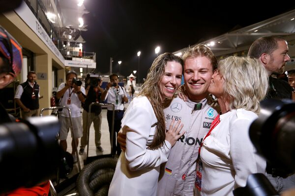 Немецкий гонщик команды Мерседес Нико Росберг со своей женой и матерью празднует чемпионство Формулы-1 после Гран-при Абу-Даби