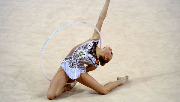 Яна Кудрявцева (Россия) выполняет упражнения с обручем в индивидуальных соревнованиях на чемпионате мира по художественной гимнастике в немецком Штутгарте