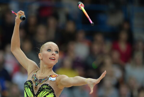 Яна Кудрявцева (Россия) выполняет упражнения с булавами в финале Гран-при по художественной гимнастике в Москве