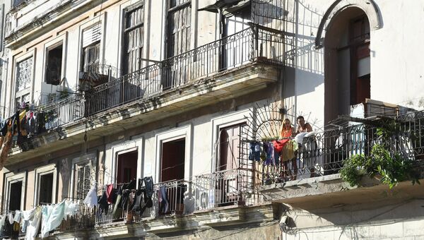 Житель на балконе здания в исторической части Гаваны