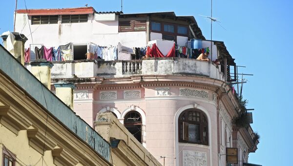 Житель на балконе здания в исторической части Гаваны
